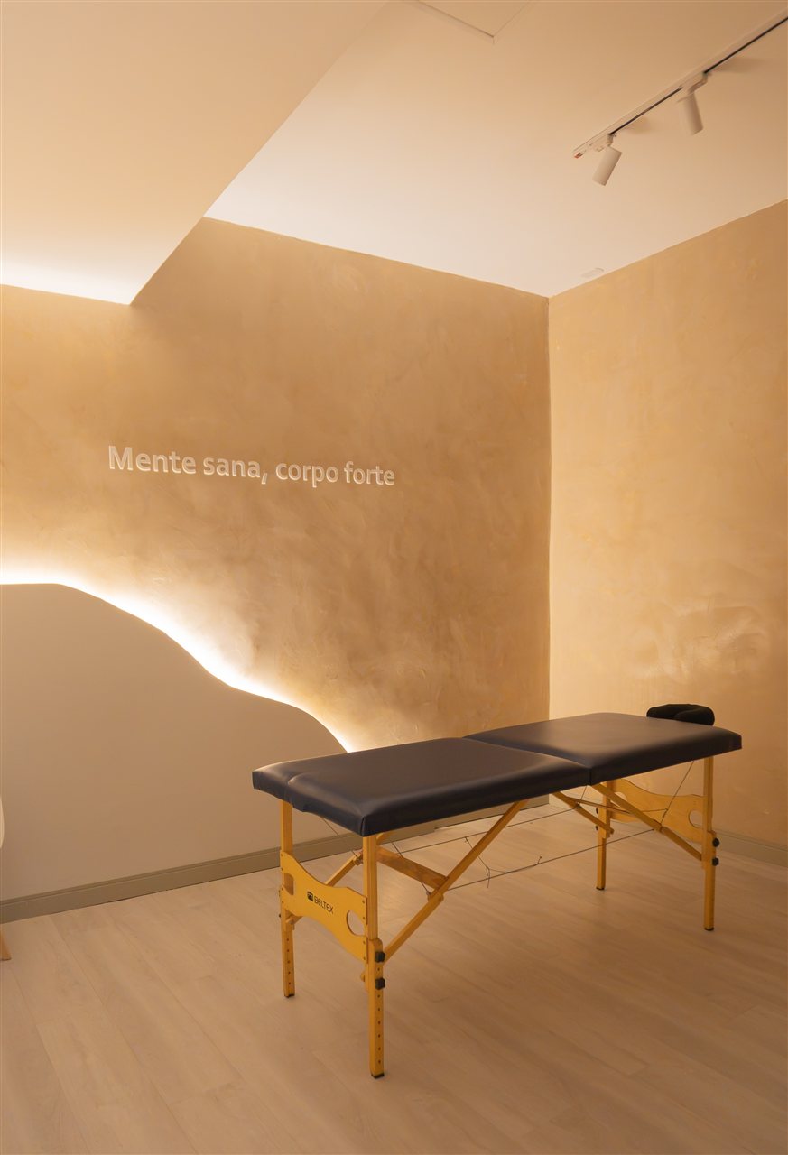 Sala exclusiva de massoterapia com maca e iluminação acolhedora